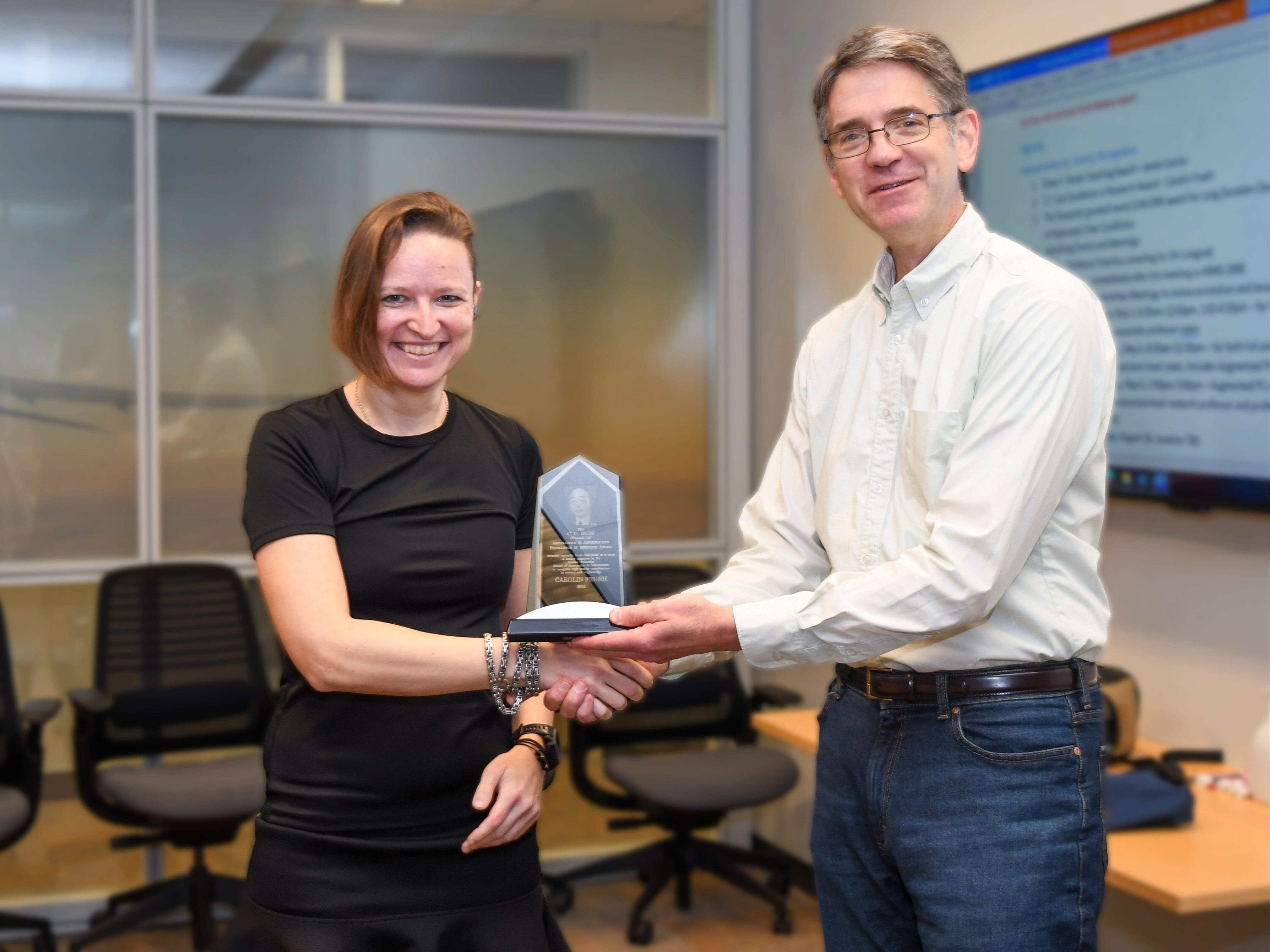 Associate professor Carolin Frueh, left, receiving the award from William Crossley, the head of AAE